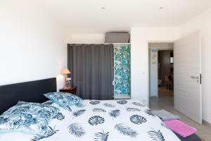 a bedroom with a bed with blue and white sheets at Chambre D'hôtes À Losari in Palasca