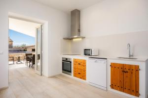 a kitchen with white walls and wooden cabinets at Son Crespi Vell 2 in Manacor