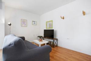 a living room with a blue couch and a tv at Casa Brando in Corralejo