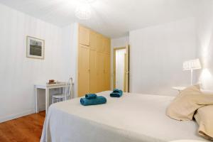 a bedroom with a white bed with blue towels on it at Casa Brando in Corralejo