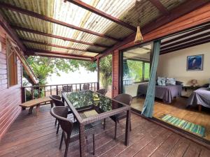 a patio with a table and chairs on a deck at Tahiti Sunrise Beach in Vaitoare +12 photos