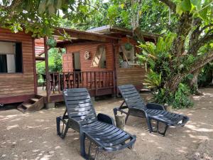 a couple of chairs sitting in front of a cabin at Tahiti Sunrise Beach in Vaitoare