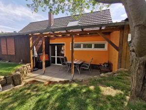 a house with a deck with a table and chairs at Ferienhaus Enger in Saalfeld