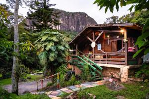 Eine Hütte im Wald mit einem Berg im Hintergrund in der Unterkunft Auá Hostel in Petrópolis