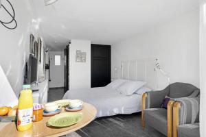 a living room with a bed and a table with a coffee table at Chambre D'hôtes Toi Et Moi - in Pornic