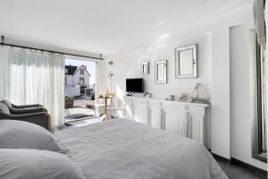 a white bedroom with a bed and a television at Chambre D'hôtes Toi Et Moi - in Pornic