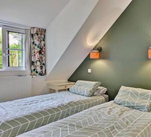 a bedroom with two beds next to a window at Gîte du moulin de Tanis in Oisseau