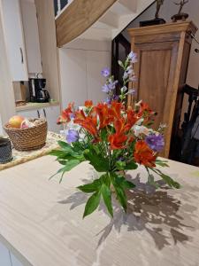 a vase of flowers sitting on a kitchen counter at Gîte du moulin de Tanis in Oisseau