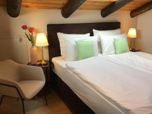 a bedroom with a white bed with two lamps and a chair at Chalet Marianna in Meltina