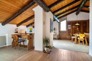 a kitchen and dining room with wooden ceilings and a table at Chalet Marianna in Meltina