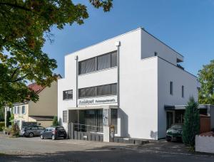 a white building with cars parked in a parking lot at Apartment 4 in Rielasingen-Worblingen