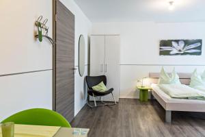 a small bedroom with a bed and a chair at Apartment 4 in Rielasingen-Worblingen
