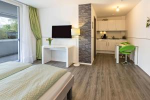 a bedroom with a bed and a desk and a kitchen at Apartment 4 in Rielasingen-Worblingen