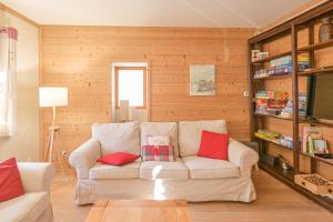 a living room with a white couch with red pillows at Chalet Reves des Cimes in Praranger