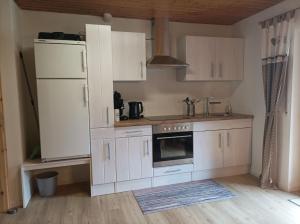 a kitchen with white cabinets and a refrigerator at Ferienwohnung Wiesenblick in Oberharmersbach