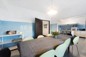 a dining room with a table and chairs and a kitchen at Sonho No Mondego in Penacova