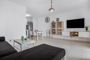 a living room with a couch and a flat screen tv at Casa Dragos in Costa Teguise