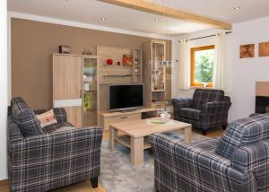 a living room with two chairs and a television at Ferienhaus Apfelbäumchen Lenzkirch in Lenzkirch