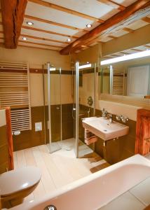 a bathroom with a tub and a sink and a shower at Ferienhaus Apfelbäumchen Lenzkirch in Lenzkirch +35 photos