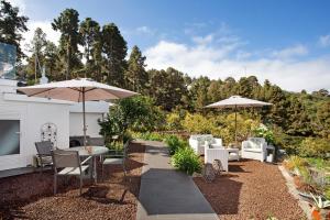 a patio with chairs and tables and umbrellas at Casa Adayeim 1 in Icod de los Vinos