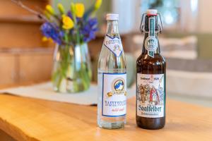 two bottles of wine sitting on a table at Ferienwohnung Am Schleifenbach 2 in Saalfeld +7 photos