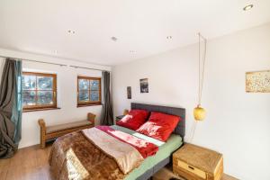 a bedroom with a bed with red pillows at Haus am Bach in Benediktbeuern