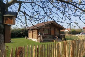 a small wooden house in a yard with a fence at Chalet Idéal Randonnée in La Chapelle-Yvon