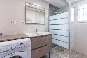 a laundry room with a sink and a washing machine at La maison des Prairies - Biscarosse in Biscarrosse +14 photos