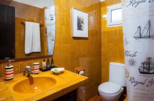 a yellow bathroom with a sink and a toilet at Villa Bini Sek in Binibeca +23 photos
