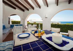 a dining room with a table with a view of the ocean at Villa Bini Sek in Binibeca