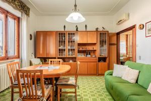 a living room with a table and a green couch at Casa nella campagna Toscana in Vinci