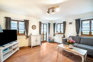 a living room with a couch and a tv at Wohnung Sonntraten in Gaißach