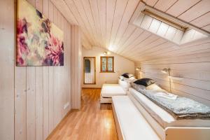 two beds in a room with wooden walls at Wohnung Sonntraten in Gaißach