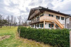 a house in a field with a fence at Wohnung Sonntraten in Gaißach