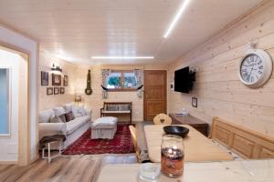 a living room with a couch and a clock on the wall at A casa di Anna in Madesimo