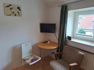 a small room with a table and a chair and a television at Algetet Apartment in Hannover