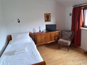 a bedroom with a bed and a tv and a chair at Algetet Apartment in Hannover