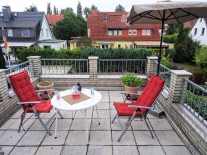 a patio with a table and two chairs and an umbrella at Algetet Apartment in Hannover