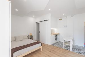 a bedroom with a bed and a small kitchen at Portblanc Loft in Arenys de Mar