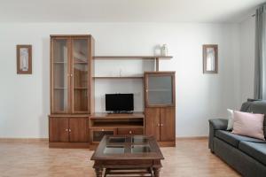 a living room with a couch and a tv at Piso Ana Paula 1 in Conil de la Frontera