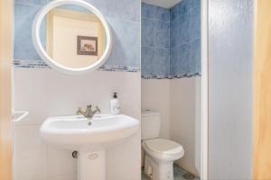 a bathroom with a sink and a toilet and a mirror at Piso Ana Paula 1 in Conil de la Frontera +11 photos
