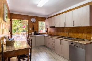 a kitchen with white cabinets and a sink and a table at Finca Can Lluc in Alaró