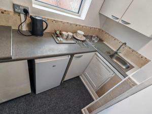 a small kitchen with a sink and a counter at Azalea Studio - Self Contained One-Bed Studio Flat in Oxford