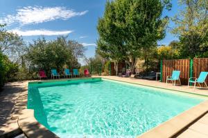 a swimming pool with chairs in a yard at Les Conils in Saint-Pierre-de-Vassols