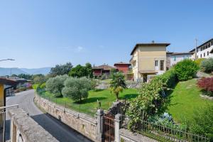 a street in a town with houses and a fence at Isola Bella Apartment in Barghe