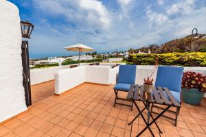 a patio with two chairs and a table and an umbrella at Alojamiento con encanto in Binibeca