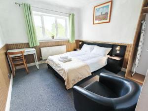 a small bedroom with a bed and a chair at Azalea Studio - Self Contained One-Bed Studio Flat in Oxford +8 photos