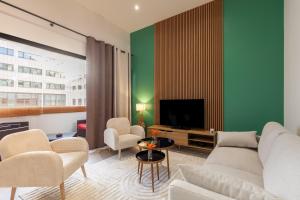 a living room with a couch and chairs and a tv at Le Castel in Marseille
