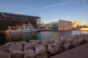 a boat in the water next to some rocks at Le Castel in Marseille