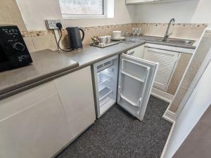 a small kitchen with a refrigerator and a sink at Azalea Studio - Self Contained One-Bed Studio Flat in Oxford
